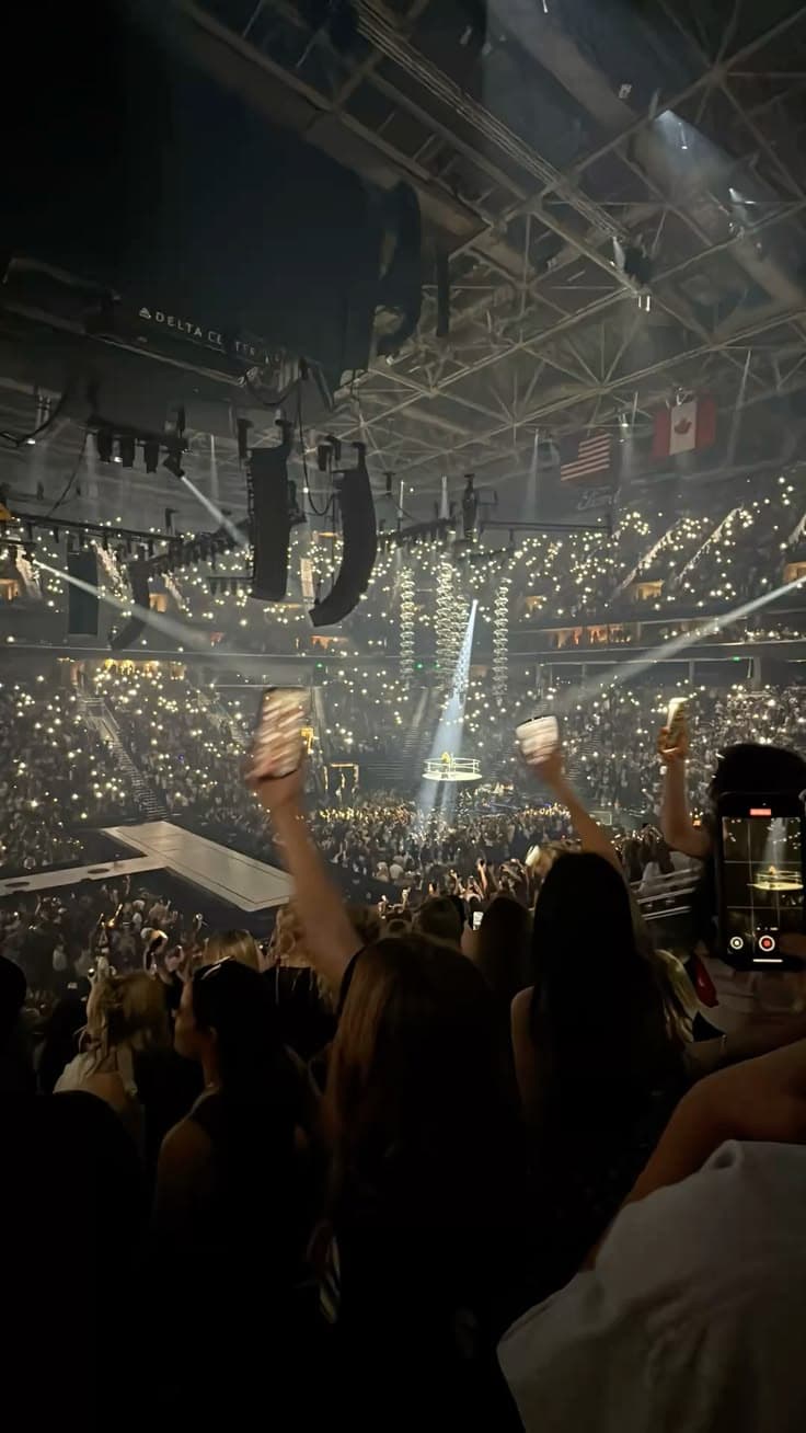 Enthusiastische Menge bei einem Indoor-Konzert mit Bühnenbeleuchtung