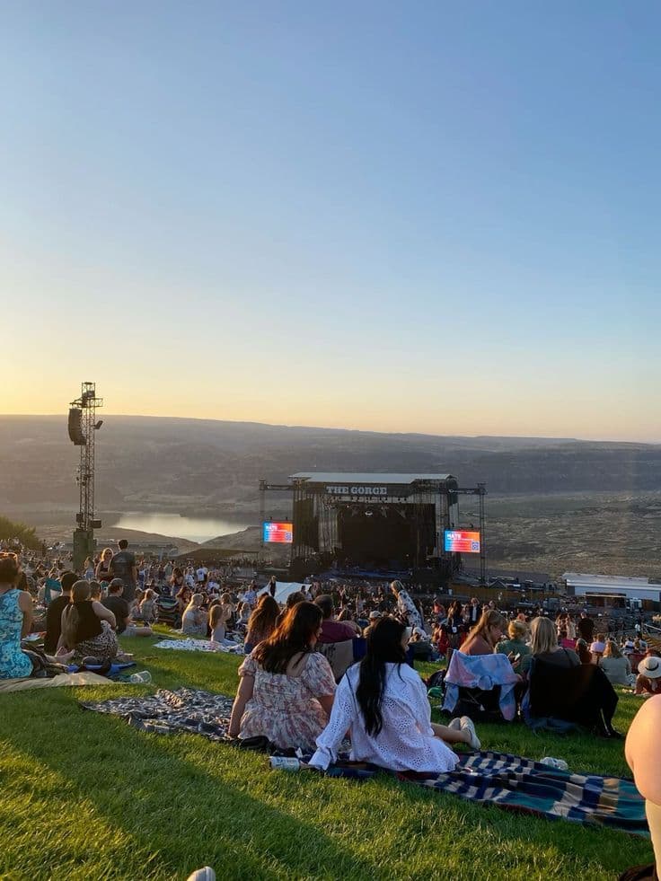 Open-Air-Konzert bei Sonnenuntergang mit tanzender Menge vor der Bühne